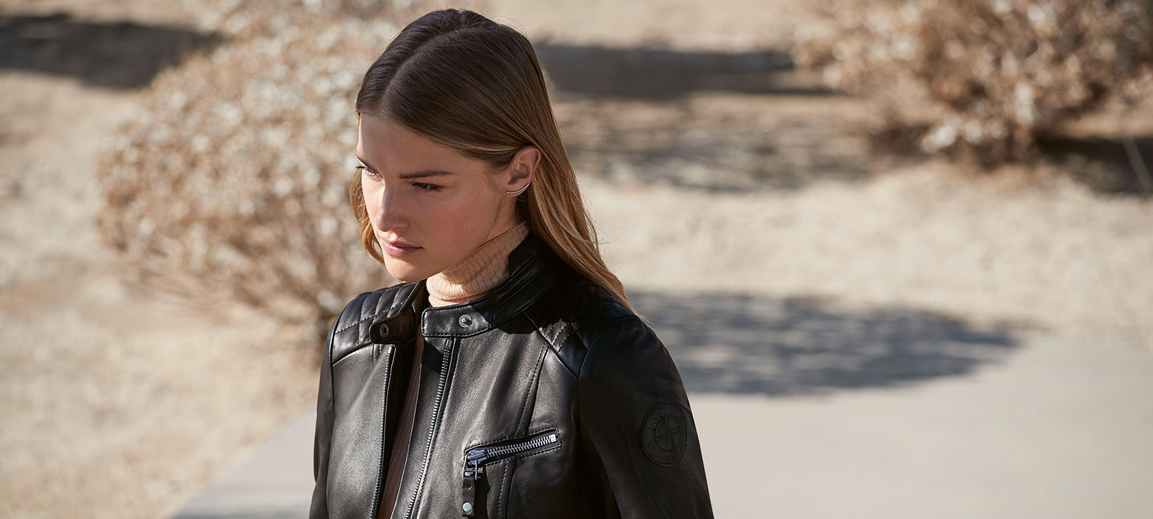 A female model is wearing the BMW Leather Jacket for ladies.